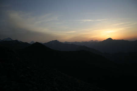 Cloudy red sunset in the mountainsの写真素材
