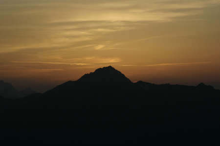 Cloudy red sunset in the mountainsの写真素材