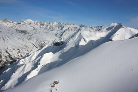 Panorama of mountain slopes and peaks in winterの写真素材