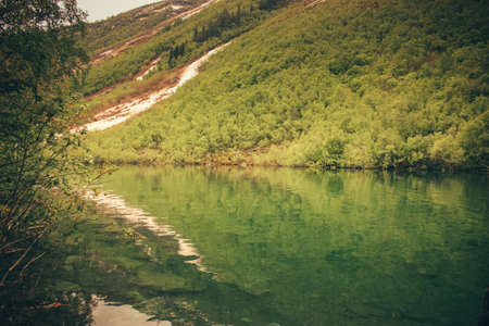 Scenery of high mountain with lake and high peak on a clear day. Pure mountain water. Clear mountain lakes in the Alpine area.の写真素材