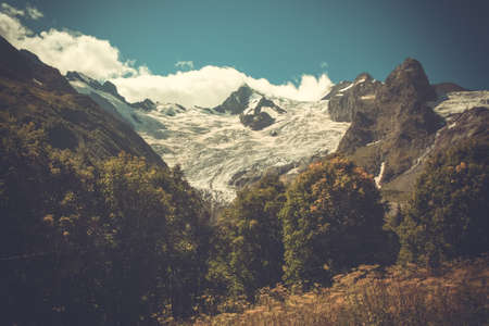 The mountain autumn landscape with colorful forest and high peaks Caucasus Mountainsの写真素材
