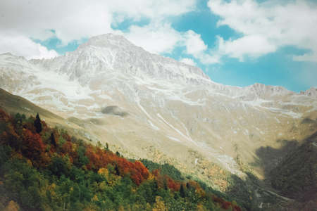 The mountain autumn landscape with colorful forest and high peaks Caucasus Mountains