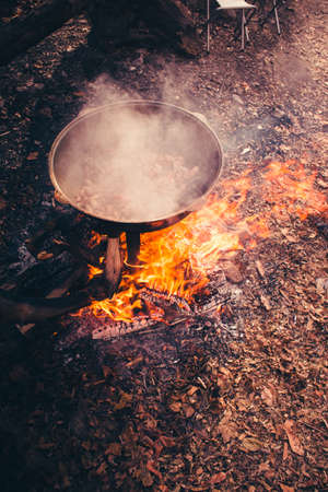 Large pot over a campfire cooking in cast-iron cauldron in nature.の写真素材