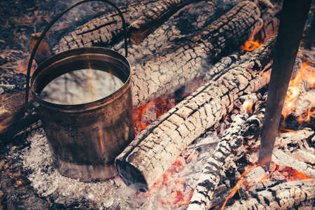 Large pot over a campfire cooking in cast-iron cauldron in nature. Food, Camping, cooking over a fire in the boilerの写真素材