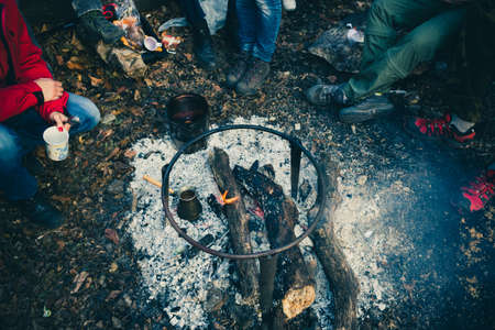 A group of people drinking tea, coffee and mulled wine in the outdoor.
Mulled wine, tea and coffee cooked over a campfire on the nature.の写真素材