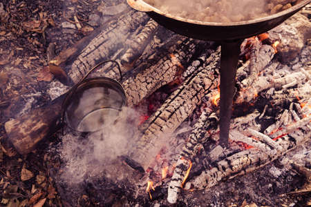 Cast iron pot and kettle outdoor, cooking on a fire. Pilaf and tea in nature.の写真素材