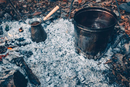Tea and coffee on the fire. A pot on a fire outdoors.Tea and coffee cooked over a campfire on the nature.の写真素材
