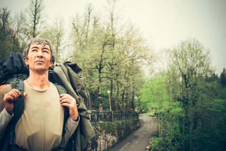 A man traveling with backpack hiking Summer journey vacations outdoor. Travel Lifestyle concept, forest and mountains on background.の写真素材
