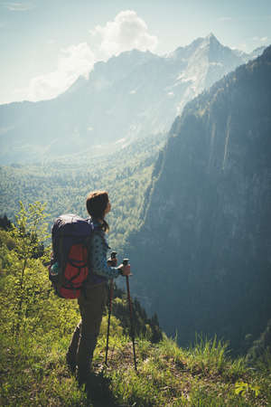 Young positive woman hiking with trekking poles and backpack resting. Travel Lifestyle concept...
