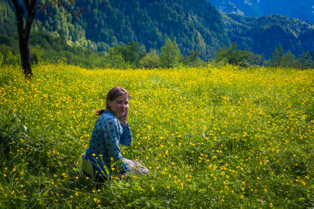 Young woman enjoying field in the meadow of flowers. Pretty girl relaxing outdoor plant, Travel Lifestyle concept.の写真素材