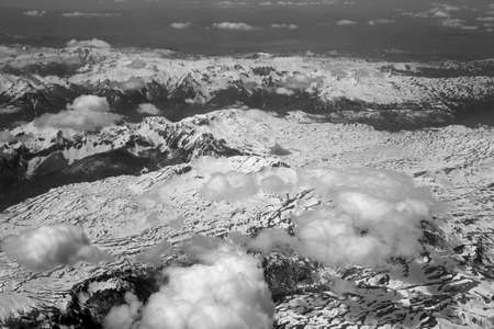 The view from the airplane window at the beautiful weather with clouds and mountainsの写真素材