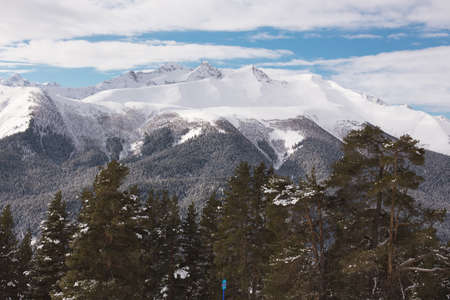 Winter landscape of snowy mountains on a clear day. The concept of travel, scenic views of rocky peaks and slopes with coniferous forest.の写真素材