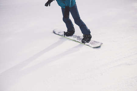 Woman snowboarder on the slopes of the resort on a winter day. Young girl on snoborde in the snow. Lifestyle vacation outdoors. The concept of vacation adventures.の写真素材