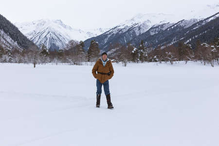 Man positive rejoices in the snow against the backdrop of mountain scenery.
Lifestyle adventure. The concept of travel, health and well-being.の写真素材