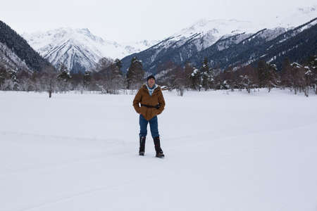 Man positive rejoices in the snow against the backdrop of mountain scenery.
Lifestyle adventure. The concept of travel, health and well-being.の写真素材