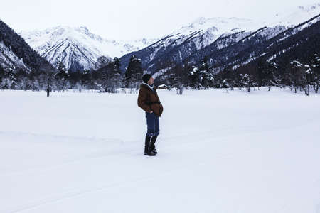 Man positive rejoices in the snow against the backdrop of mountain scenery.
Lifestyle adventure. The concept of travel, health and well-being.の写真素材
