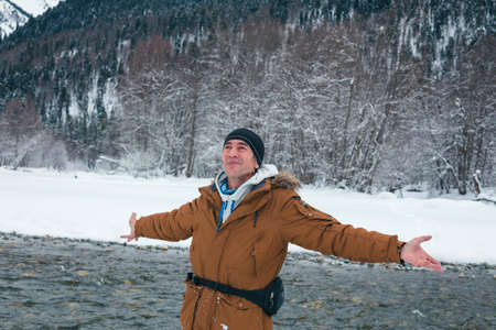 Man positive rejoices in the snow against the backdrop of mountain scenery.
Lifestyle adventure. The concept of travel, health and well-being.の写真素材