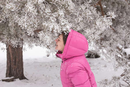 Woman with holiday Lifestyle in the winter forest. Happy little girl playing in the snow against a pine forest. The concept of active holiday adventures in the wild.の写真素材