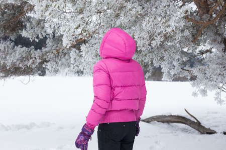 Woman with holiday Lifestyle in the winter forest. Happy little girl playing in the snow against a pine forest. The concept of active holiday adventures in the wild.の写真素材