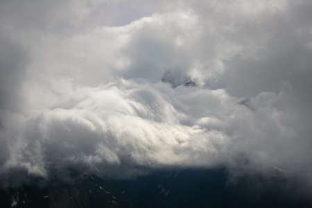 Rocky Mountain cliffs and clouds illuminated by the sun. Travelling Landscape in cloudy weather...