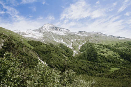 Mountains green landscape with blue sky and white clouds. Lifestyle is active, hiking, tourism. Picturesque landscapes of the Alpine mountains in the summer season.の写真素材