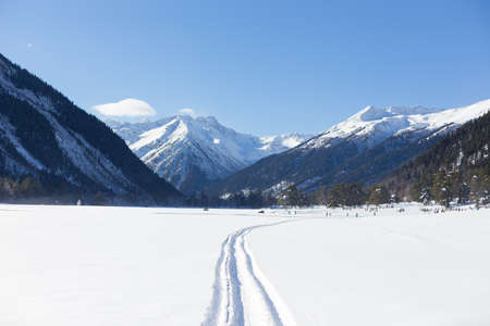 Winter panorama of the mountain with valleys and forest. Caucasus. Landscape of high peaks in clear weather. The concept of travel and leisure, winter sports, lifestyle, adventure.の写真素材