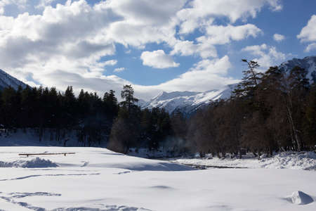 Winter panorama of the mountain with valleys and forest. Caucasus. Landscape of high peaks in clear weather. The concept of travel and leisure, winter sports, lifestyle, adventure.の写真素材