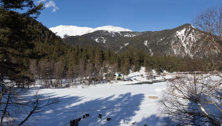 Winter panorama of the mountain with valleys and forest. Caucasus. Landscape of high peaks in clear weather. The concept of travel and leisure, winter sports, lifestyle, adventure.の写真素材
