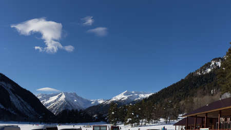 Winter panorama of the mountain with valleys and forest. Caucasus. Landscape of high peaks in clear weather. The concept of travel and leisure, winter sports, lifestyle, adventure.の写真素材