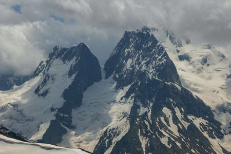 Mountain landscapes and summits on a sunny day. Caucasus. Landscape alpine species in the summer season. The concept of travel and recreation, winter sports, lifestyle, adventure.の写真素材