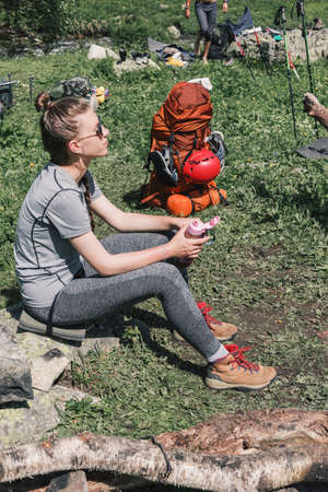 Girl in hiking boots, having fun and enjoying the rest at the camps admiring the nature. The concept of rest for a holiday in hikes, traveling lifestyle adventure summer vacations outdoor.の写真素材