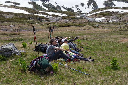 Travelers, vacationers in the mountains, discuss the route, admiring the nature. The concept of the adventure of a healthy lifestyle is relaxing outdoors.の写真素材