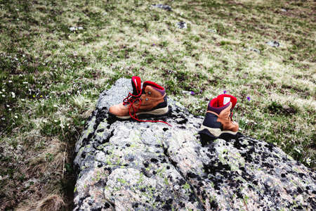 Two tourist traveller hiker shoes boots standing on stones.の写真素材