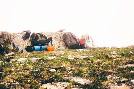 Backpacks of travelers against a background of a cliff in cloudy weather with a fog. The concept of travel and adventure.の写真素材