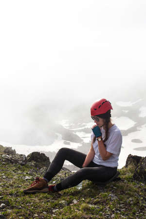 A tourist girl is sitting on top of a mountain.. Travel lifestyle adventure concept active outdoor recreation hiking.の写真素材