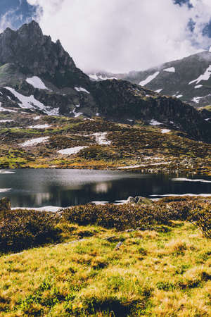 Stunning view of a green mountain hill located near a clean lake on a sunny spring day. Travel Lifestyle concept adventure active summer vacations outdoor.の写真素材