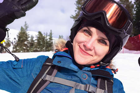 Woman snowboard in helmet and mask. Portrait girl snowboard closeup. Sport holidays in the mountains. Travel Lifestyle winter adventure concept, activities vacations outdoor in holidays.の写真素材