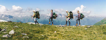 Sports travel background photo collage group of people hipster friends extreme tourists with backpacks on top of mountain Lifestyle Adventure hiking or expedition concept the background of high peaksの写真素材
