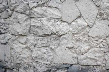 Wall decorative stone texture background painted white. Masonry as a cladding of exterior buildings and structures.の写真素材