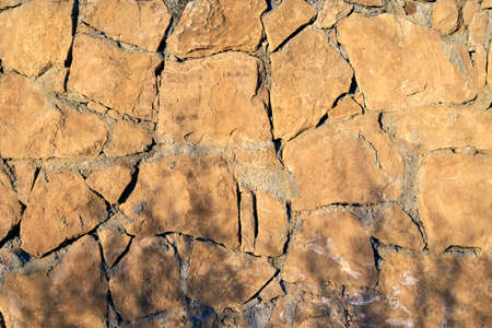 Facing stone wall texture background. Modern decor outdoor rocks. Tile textured of general layout of stones masonry with mixed block. Decorative grunge coarse stonework city.の写真素材