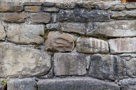 Wall stone grunge texture background. Grungy vintage fortress granite and sandstone. Rough old stone or rock of mountains. Front antique decor castle. Masonry house layout slate.の写真素材