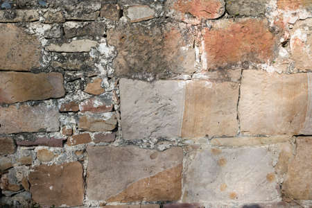 Stone wall grunge texture background. Rough old stone or rock of mountains. Grungy vintage fortress granite and sandstone. Front antique decor house. General layout of stone masonry.の写真素材
