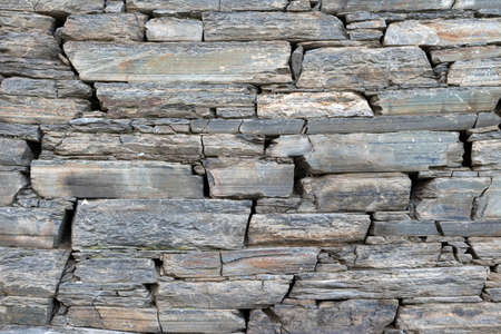 Stone rock texture background. Wall rough old piece rock of mountains. Natural stone masonry without mortar and cement, an old fortress building, a castle wall made granite of blocks.の写真素材
