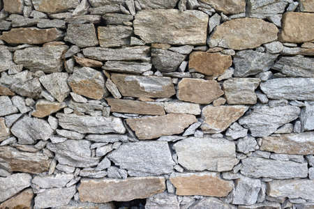 Stone rock texture background. Natural stone masonry without mortar and cement, an old fortress building. Castle wall made granite of blocks. Wall rough old piece rock of mountains.の写真素材