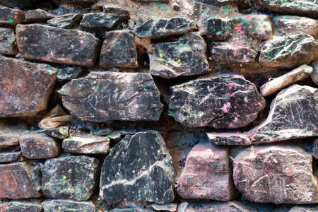 Grunge texture stone wall background. Rough old stone or rock texture of mountains. Coarse facing, grungy aged stonework city. Front antique decor house. General layout of stone masonry.の写真素材