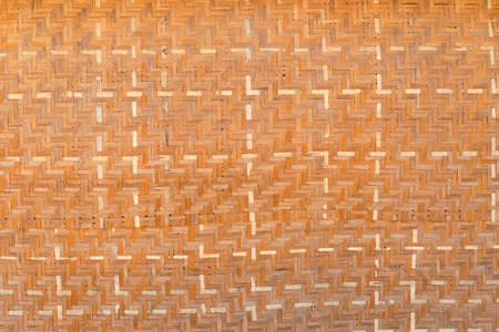 Bamboo brown straw mat, abstract background texture wicker composition. Woven palm wood pattern. Interlocking of coconut leaves. Weaved mat from dried palm leaves.の写真素材