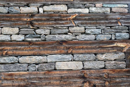 Wooden bands and dry-stacked rubble stone masonry. Abstract background texture mixed for old stone walls. Traditional building technology Himalaya, Nepal. Tibetan village houseの写真素材