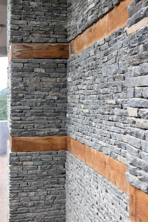 Wooden bands and dry-stacked rubble stone masonry. Abstract background texture mixed for old stone walls. Traditional building technology Himalaya, Nepal.の写真素材