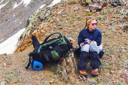Woman traveler hiking in mountains with backpack on campsite Travel Lifestyle adventure concept active summer vacations outdoor mountaineeringの写真素材