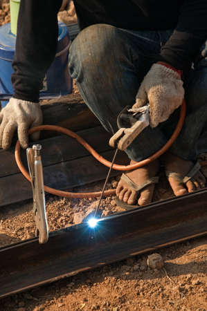 Worker welding steel with welding metal and sparks.の写真素材